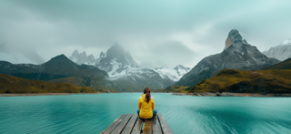 A lady next to a lake and mountains